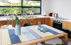 Una cocina con una mesa con un jarrón encima. en Das Sommerhus 68, en Noordwijk