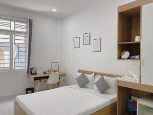 a white bedroom with a bed and a desk at Hello SaiGon Homestay in Ho Chi Minh City