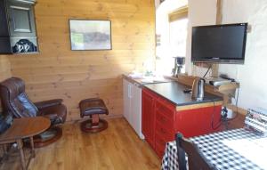 a room with a desk with a television and chairs at Cozy Apartment In Sandnes With Kitchen in Bråstein
