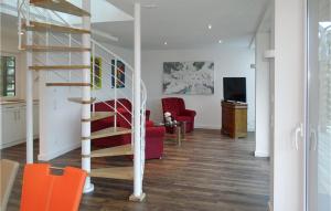 a living room with a spiral staircase and red chairs at Haus 3 in Wendorf