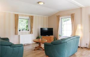 a living room with two blue chairs and a tv at Vlinder Oase in Rheezerveen