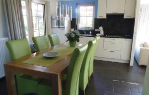een keuken met een houten tafel en groene stoelen bij Buitengoed Het Lageveld - 119 in Hoge-Hexel
