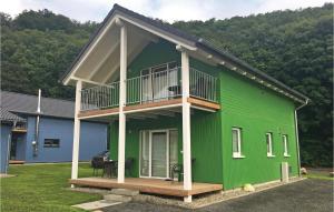 ein grünes Haus mit Balkon darüber in der Unterkunft Ferienhausdorf Thale in Thale