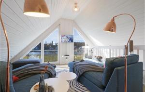 ein Wohnzimmer mit zwei blauen Sofas im Dachgeschoss in der Unterkunft Cozy Home In Zerpenschleuse With Wifi in Zerpenschleuse