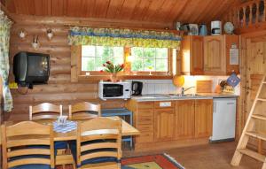 a kitchen with a table and a television in a cabin at 2 Bedroom Beautiful Home In Sunne in Sunne