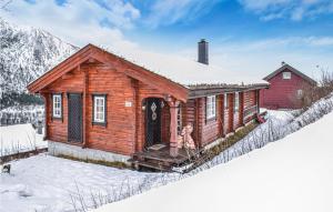a log cabin in the snow with a red house at 3 Bedroom Amazing Home In Vossestrand in Vossestrand