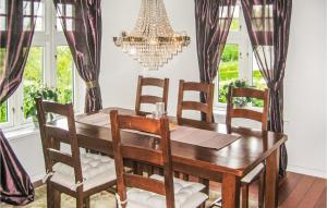 una sala da pranzo con tavolo, sedie e lampadario pendente di 4 Bedroom Stunning Home In Rong a Rong