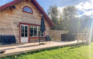 a house with a deck with a grill and an umbrella at Stunning Home In Huskvarna With Kitchen in Huskvarna