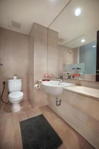 een badkamer met een wastafel, een toilet en een spiegel bij favehotel Melawai in Jakarta