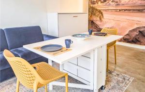 einen weißen Tisch mit zwei Stühlen und einem Sofa in der Unterkunft Windwijser in Bergen aan Zee