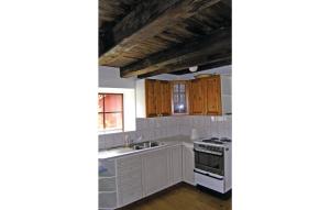 a kitchen with white cabinets and a stove at Amazing Home In Skillingaryd With 2 Bedrooms in Ryd