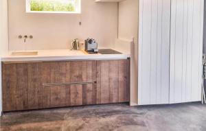 eine Küche mit Holzschränken und einer Arbeitsplatte in der Unterkunft Windwijser in Bergen aan Zee