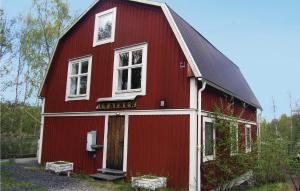 a red barn with two windows on the side of it at Amazing Home In Skillingaryd With 2 Bedrooms in Ryd