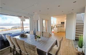 a dining room with a table and chairs and a large window at Åmland Hyttefelt in Korshamn