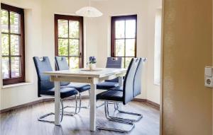a dining room with a table and blue chairs at Gorgeous Apartment In Brilon-madfeld With Wifi in Madfeld