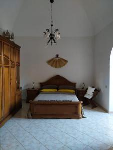 1 dormitorio con cama y lámpara de araña en DIMORA LETIZIA -APARTMENT en Procida