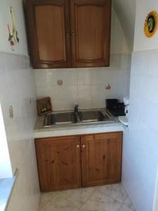 una cocina con armarios de madera y fregadero en DIMORA LETIZIA -APARTMENT en Procida