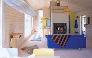 a living room with a blue couch and a fireplace at Awesome Home In Ballangen With Kitchen in Langvåg