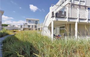 a house with a balcony and some tall grass at Dünenvilla 7, Whg 5 in Travemünde