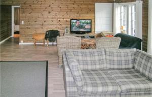 - un salon avec un canapé, des chaises et une télévision dans l'établissement Lovely Home In Straumgjerde With House Sea View, à Brunstad