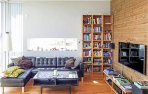 uma sala de estar com um sofá de couro e prateleiras de livros em Lovely Apartment In Bokn With House Sea View em Kro