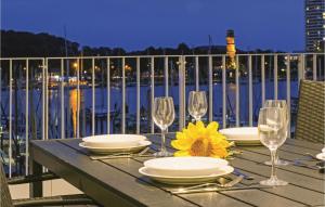 a table with wine glasses and a sunflower on a balcony at Priwallpromenade 23, Whg 10 in Travemünde