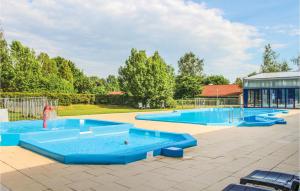 une grande piscine avec des tables bleues et un toboggan dans l'établissement Lovely Home In Gramsbergen With Indoor Swimming Pool, à Gramsbergen