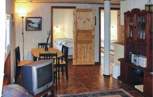 1 dormitorio y sala de estar con TV y mesa. en Gorgeous Apartment In Hauge I Dalane With House Sea View en Sogndalsstrand