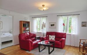 a living room with a red couch and a table at Holiday Home Asarum Gamla Tingsrydsvägen in Askaremåla