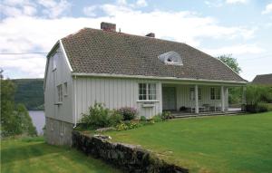 une petite maison blanche avec une cour d'herbe dans l'établissement Gorgeous Home In Vestsida With House Sea View, à Hov