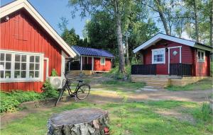Amazing Home In Kvicksund With Wifi في Kvicksund: منزل احمر به دراجة متوقفة امامه