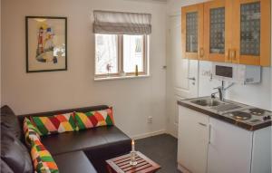uma pequena sala de estar com um sofá e uma cozinha em 1 Bedroom Stunning Home In Vrng em Vrångö