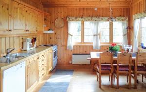 eine Küche mit einem Tisch und Stühlen im Zimmer in der Unterkunft Cozy Home In Varaldsy With Kitchen in Gjuvsland