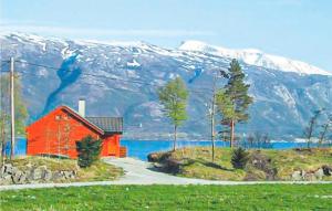 eine rote Scheune vor einem schneebedeckten Berg in der Unterkunft Cozy Home In Varaldsy With Kitchen in Gjuvsland