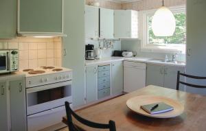 uma cozinha com armários brancos e uma mesa de madeira em Lovely Home In Olofstrm With Sauna em Olofström