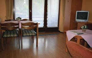un soggiorno con tavolo e TV di Hotel Drosson a Wirtzfeld