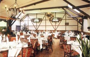 un salón de banquetes con mesas y sillas blancas en Hotel Drosson, en Wirtzfeld