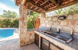 a stone kitchen with a sink and a swimming pool at 3 Bedroom Nice Home In Laatchi in Prodhromi