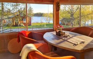 ein Esszimmer mit einem Tisch und Stühlen sowie einem großen Fenster in der Unterkunft Lovely Home In Storsvartrsk With Kitchen 