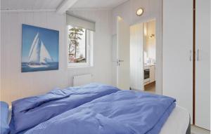 a bedroom with a blue bed with a sailboat on the wall at Dnenpark 18 - Dorf 6 in Priwall