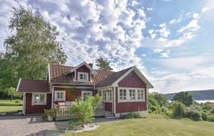 ムンケドルにあるStunning Home In Munkedal With 2 Bedrooms And Wifiの小さな赤い家(芝生の上にバルコニー付)