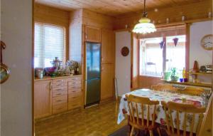 een keuken met een tafel en een koelkast. bij Lovely Home In Storsvartrsk With Kitchen 