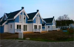 ein großes Haus mit blau und weiß in der Unterkunft Amazing Home In Breege Ot Juliusruh With Kitchen in Juliusruh