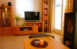 ein Wohnzimmer mit einem Tisch und einem Flachbild-TV in der Unterkunft Amazing Home In Breege Ot Juliusruh With Kitchen in Juliusruh