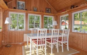 a dining room with a white table and chairs at Awesome Home In Munkedal With Wifi in Munkedal +15 photos