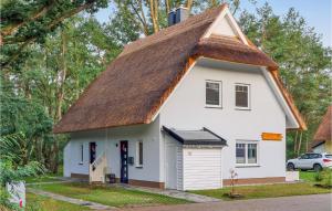 a small white house with a thatched roof at Reetdachhausschilf-Idyll in Kutzow
