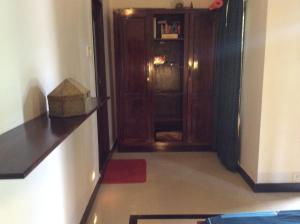a hallway with a wooden door and a room with a red rug at Reuben Villa in Kovalam