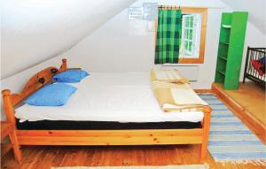 ein Schlafzimmer mit einem Holzbett mit blauen Kissen in der Unterkunft Cozy Home In Nshulta With Kitchen in Berga