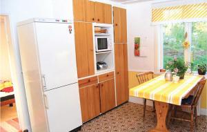 eine Küche mit einem Tisch und einem weißen Kühlschrank in der Unterkunft Cozy Home In Nshulta With Kitchen in Berga