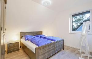 a bedroom with a bed with blue sheets and a window at Reetdachhaus 26 Auf Usedom in Kutzow